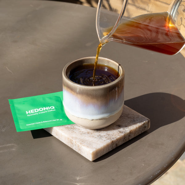 Essential box sachet and coffee jug pouring into ceramic cup