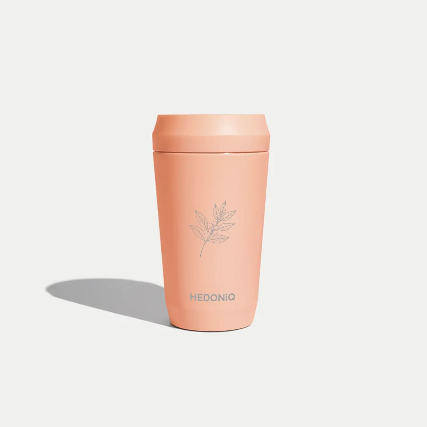Hedoniq peach reusable travel cup with minimalist coffee branch design.
