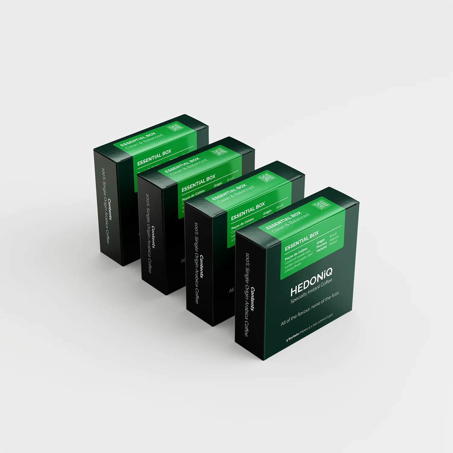 Four boxes of Hedoniq Essential Box specialty instant coffee, arranged in a staggered row on a light background.